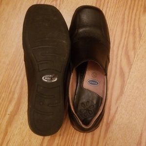 Black Dr. Scholls shows with a low heel.